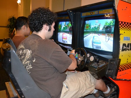 Students race cars on the Daytona USA video game.