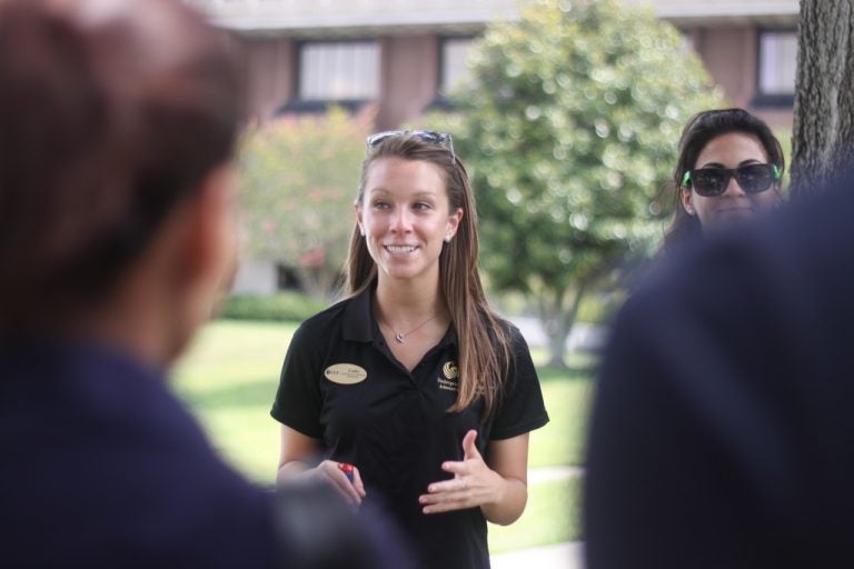 Cathy Eble explains the tradition of Spirit Splash by the Reflecting Pond to prospective students. Photo credit: Chelsea St. John/Central Florida Future