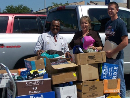 Volunteer Coordinator Fred Homes and Volunteer Specialist Renee Frosbutter, both of the Orlando VA Medical Center, accept donations from UCF student Michael Sosinski.