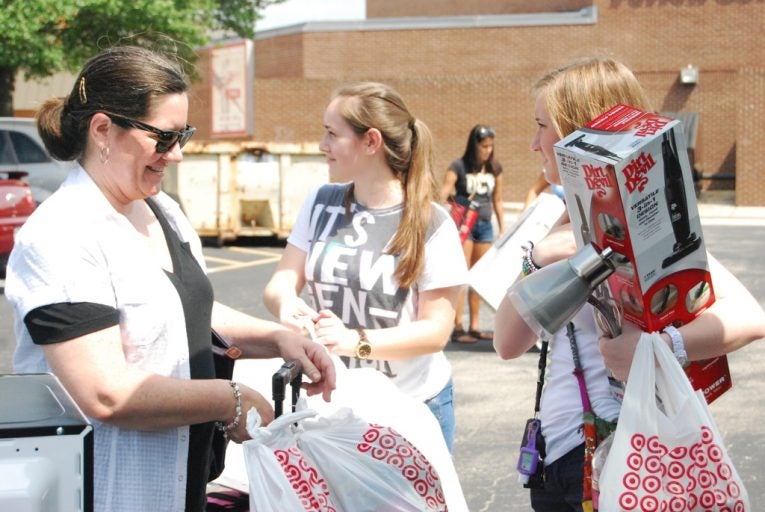 Savannah Stegall / Central Florida Future.—Freshman legal studies major Elizabeth Irazabal, center, carries her things into Libra with her family during early move-in on Sunday, Aug. 14.