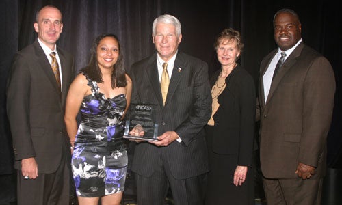 Angelica Mealing, a student in the DeVos Sport Business Management program, with her Courageous Student-Athlete award. Presenters were Greg Brown, assistant coach for the UCF women's basketball team; Dr. John C. Hitt, UCF President, and his wife, Martha; and Keith Tribble, athletic director at UCF.