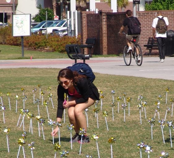 Student selects a pinwheel to support a smoke-free campus.