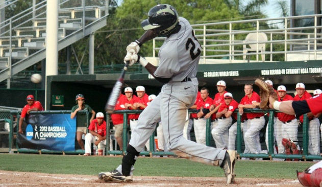 baseball player swings at a pitch