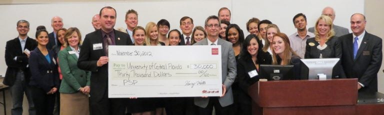 Representatives from Wells Fargo present the college with a check for $30,000.