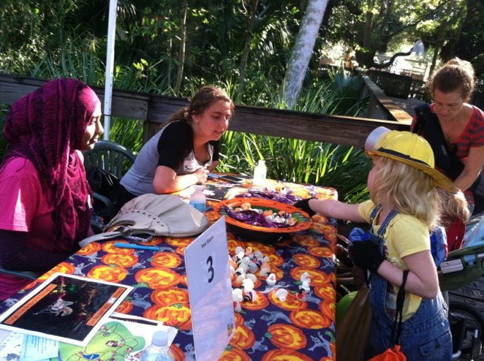 Volunteers uKnighted LLC residents in Neptune greet children with candy at the "Zoo Boo Bash" held at the Central Florida Zoo.