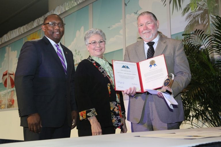 Christopher Epps, president of the American Correctional Association, and Betty Adams Wooten, chair of ACA’s Correctional Awards Committee, presented the Lejins Award to Professor Roberto Hugh Potter.
