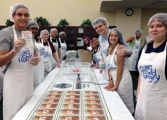 Students pack meals to feed children and combat hunger.