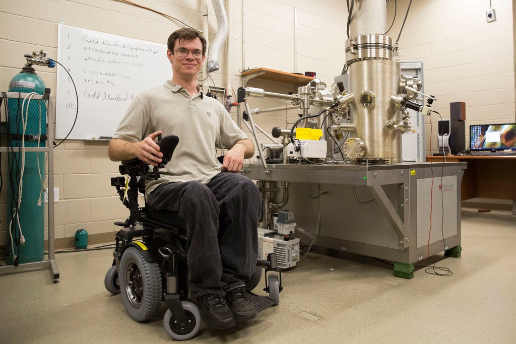 Doctoral student Michael Lodge received a wheelchair with a seat lift, enabling him to see into the electron microscope where he conducts research. Photos by Lauren Haar/UCF
