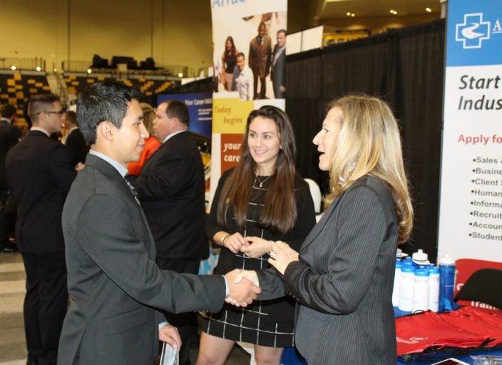Student and employer greet one another at the Career Expo.