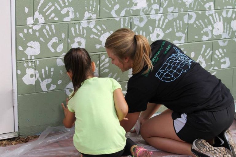 ucf student volunteer with young children