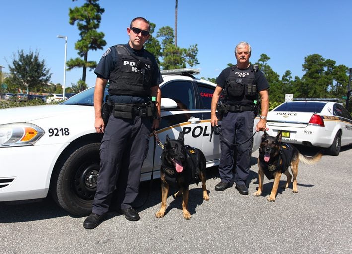 Jogy (left, with Ofc. Chris Holt) and Max (right, with Cpl. Chuck Reising) are safer thanks to a donation by Canine Wounded Heroes. Photos by Nick Russett
