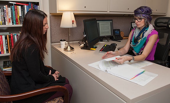 2013-14 research fellow Kristina Childs (left) mentors current fellow Jennifer Peck as part of the fellows program. Both are members of the criminal justice faculty.