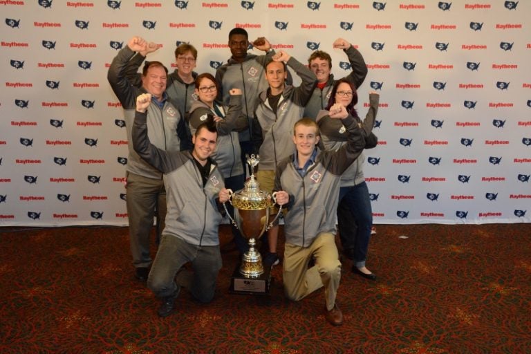 UCF students, pictured with faculty advisor Thomas Nedorost, won their third consecutive National Collegiate Cyber Defense Competition championship. Photo courtesy Raytheon Company