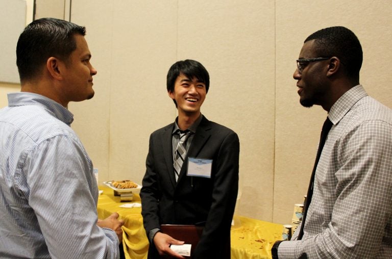 Electrical engineering majors Brandon Carty and Jihang Li discuss job options with Felix Lugardo of Power Grid Engineering, a national firm with an office in Lake Mary. (Photo by Clara Winborn)