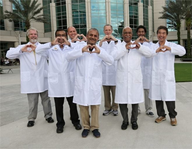 Heart Heroes in white lab coats making hearts with their hands