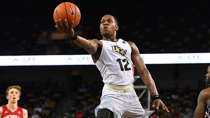 ucf basketball player in white uniform reaching for the basketball