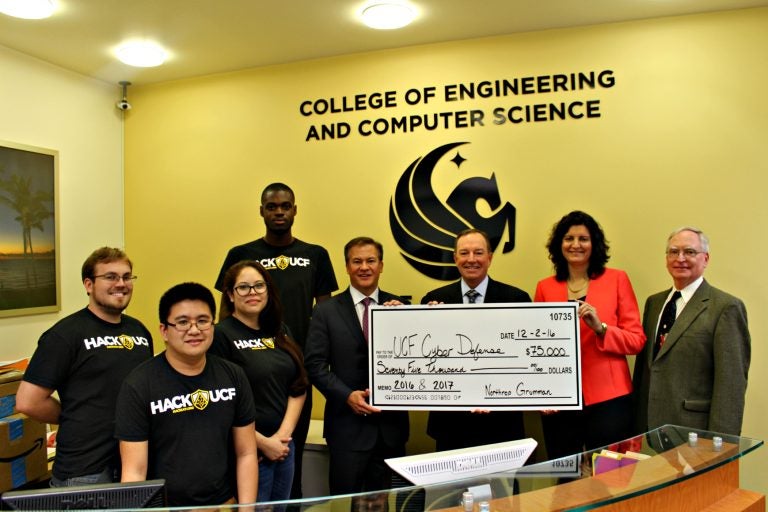 Executives from Northrop Grumman present a sponsorship check to UCF's Collegiate Cyber Defense Club.