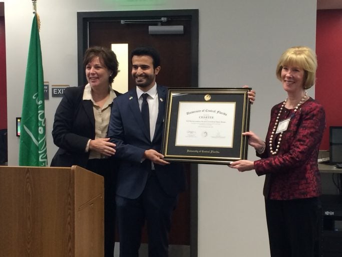 Cynthia Young, Vice Provost for Faculty Excellence, awards a charter to UCF International Alumni Chapter of Saudi Arabia Chair Yahya Alassaf .To the right is Senior Associate Vice President for UCF Advancement Julie Stroh.