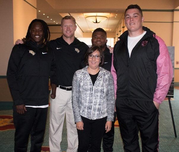 UCF Football's Shaquem Griffin, Coach Scott Frost, Mark Rucker and Aaron Evans with Dr. Annette Khaled at the AutoNation Cure Bowl Press Conference.