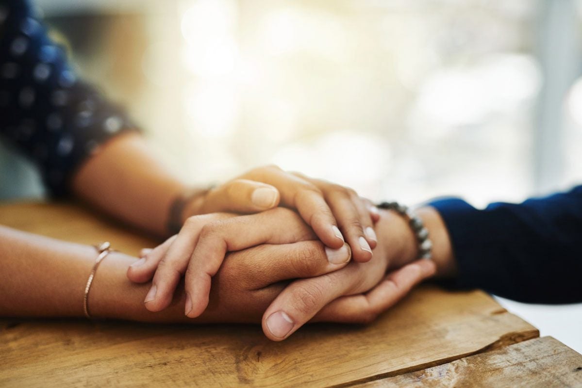 closeup of two sets of hands holding each other