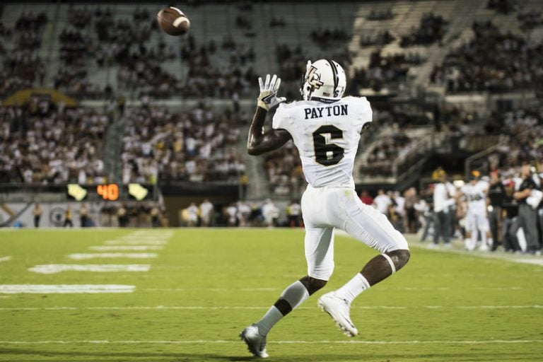ucf footbal player in white uniform about to make a catch