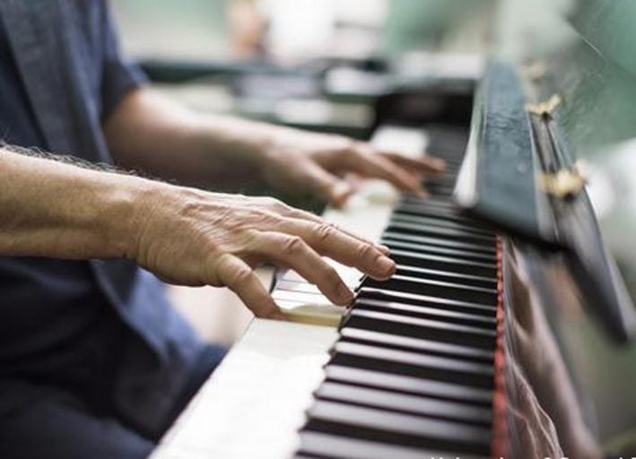 visual of mans hands playing piano