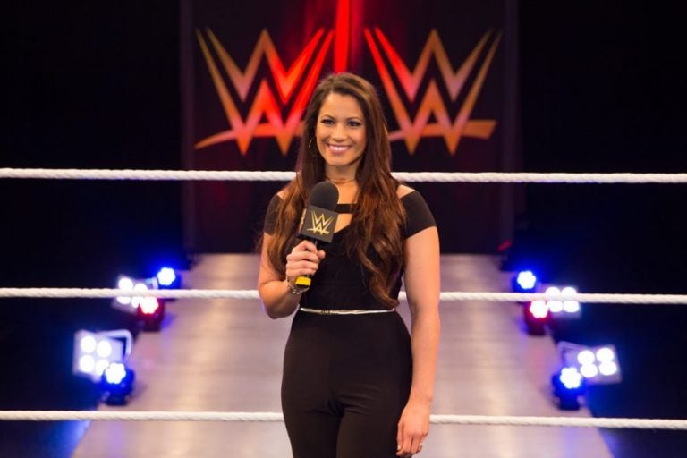 dasha fuentes standing in wwe ring, holding microphone