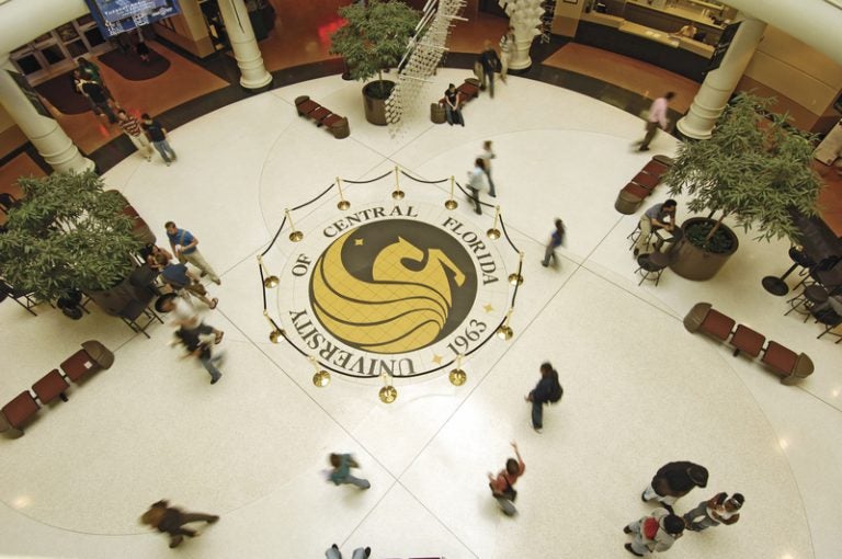 aerial shot of pegasus seal in student union, with students walking by