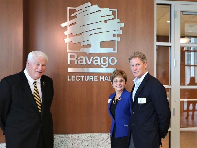 president hitt with man and woman in front of ravage logo on inside wall of building