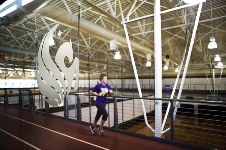 student walking by pegasus logo at ucf recreation and wellness center