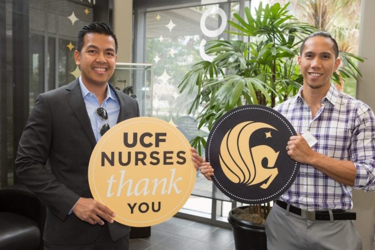 Alvin Cortez, Richard Manuel posing with pegasus sign and UCF nurses thank you signs