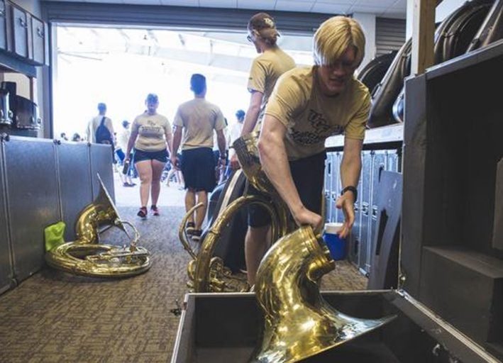 students getting ready for marching knights. male student taking out his brass instrument