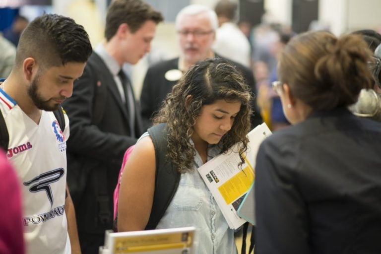 students looking at paperwork at ucf grad fair 2016