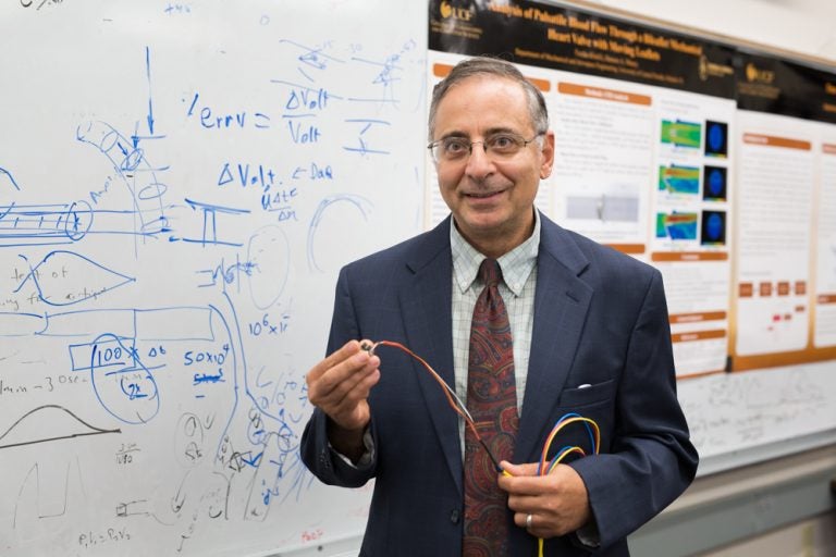 Hansen Mansey standing in front of whiteboard, smiling