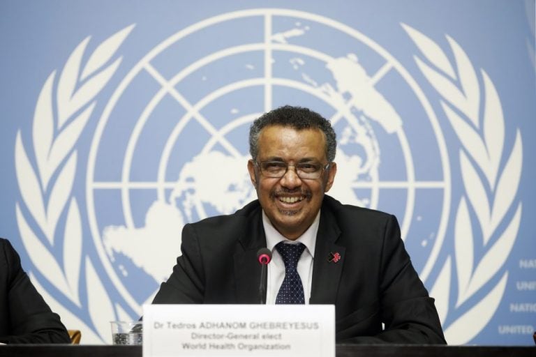 man sitting and smiling at world health organization