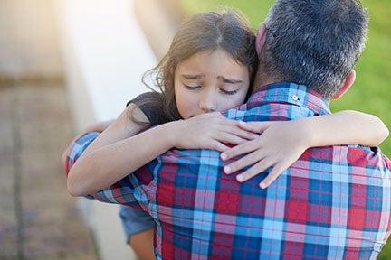 man in plaid shirt hugging distressed young girl with eyes closed