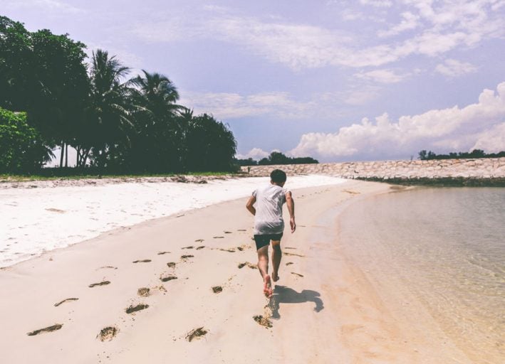 man running on sandy beach
