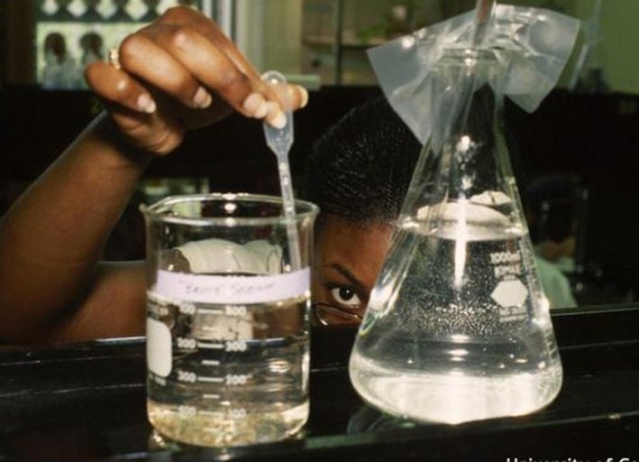 Photo of student and beakers