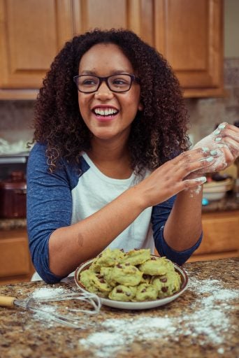 black student excited and smiling while baking cookies