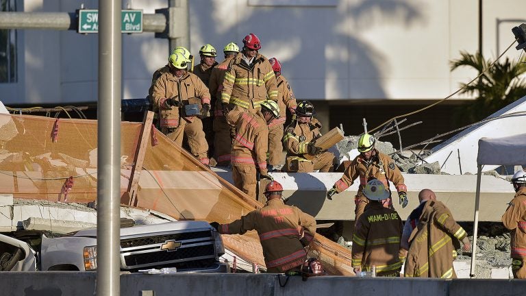 Miami-Dade Fire Rescue firefighters respond to a 950-ton pedestrian bridge under construction that collapsed March 15. (Photo by Michael Laughlin, South Florida Sun Sentinel)