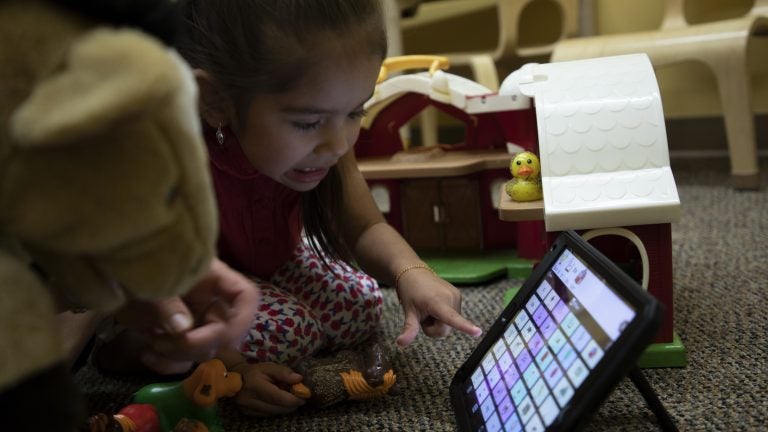 A child examines an app where words can be selected in sequential order and then the app verbally communicates that sentence for the user. Photo credit: University of New Mexico.
