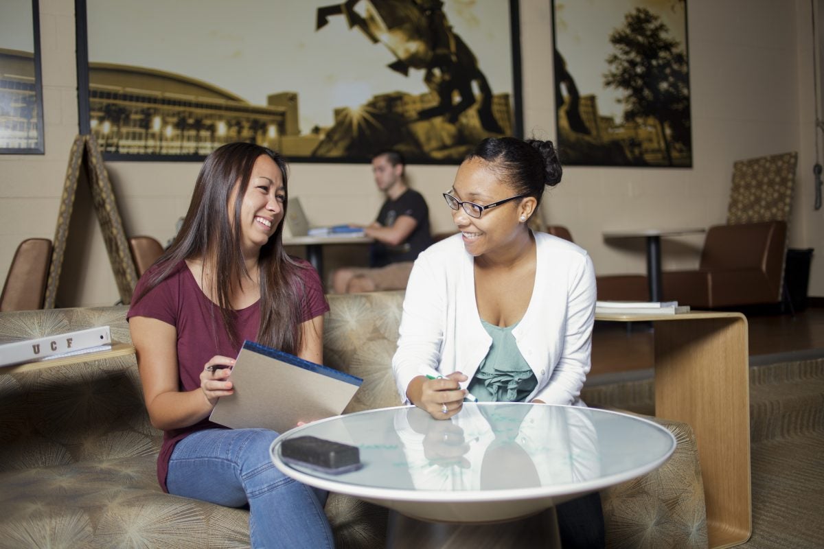 two ucf students sitting around a table talking