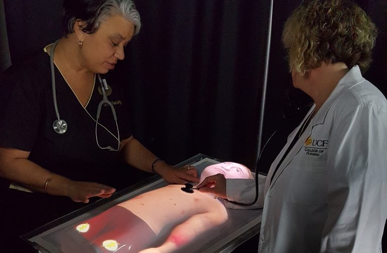 Nursing healthcare simulation educators with pediatric physical-virtual patient bed prototype