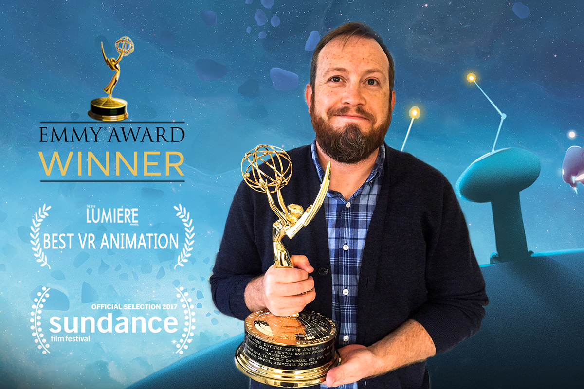 man with brown hair holding emmy award