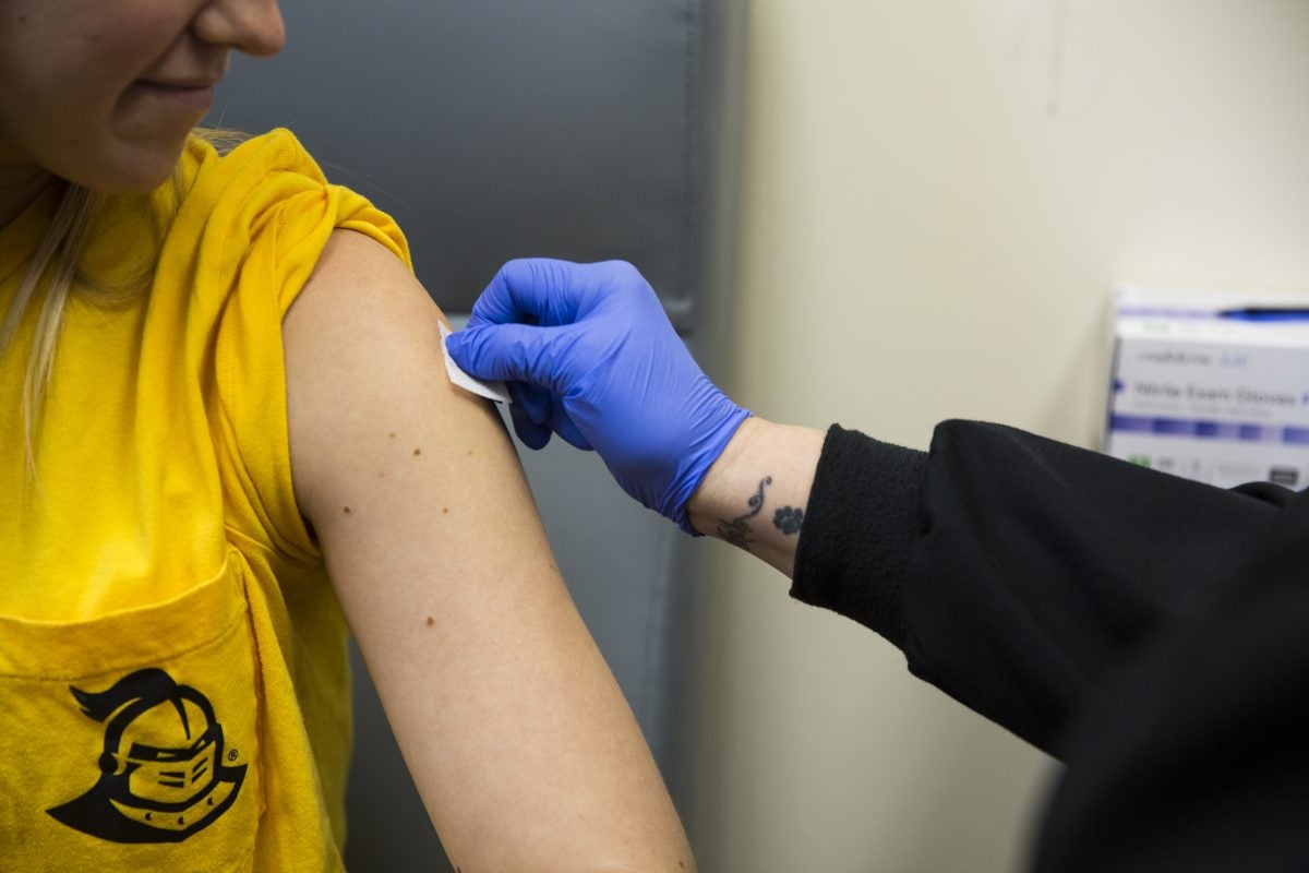 ucf health worker preparing to give flu shot to student