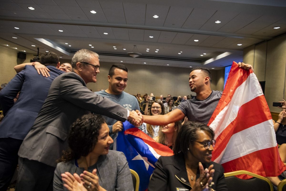 President Whittaker shakes hands with members of the Puerto Rican Student Association.