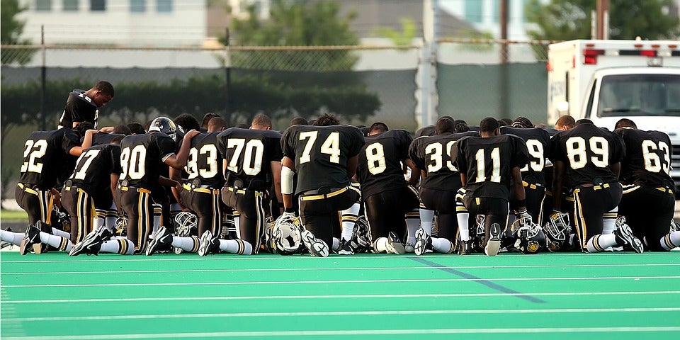 Football players kneeling.