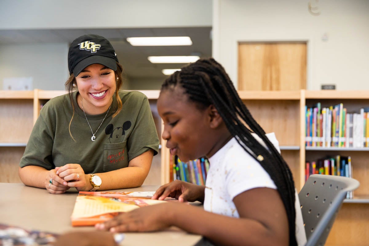 As an intern for UCF Downtown, senior writing and rhetoric major Melissa Mitchum works with an elementary school student.