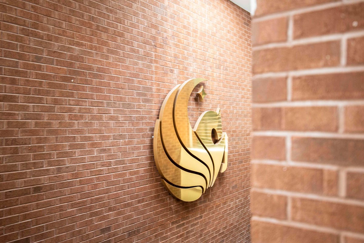 brick wall with a shiny, gold pegasus logo fixture