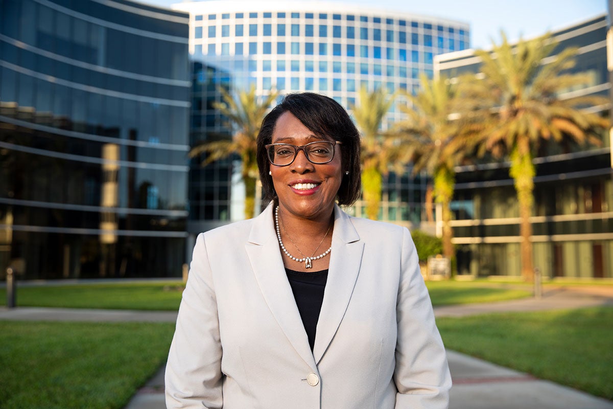 Provost Elizabeth Dooley, wearing a tan blazer, in front of the UCF Teaching Academy